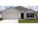 Charming single-story home featuring a white stucco exterior, attached garage, and a well-manicured lawn at 4714 Sw 88Th Ln, Ocala, FL 34476