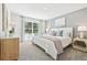 This bedroom has carpet and a view of the back yard from the window by the bedside table at 4714 Sw 88Th Ln, Ocala, FL 34476