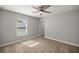 Neutral bedroom featuring a ceiling fan, window and carpeted floors at 5144 Ne 9Th St, Ocala, FL 34470