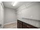 Practical laundry room with granite countertop, cabinets, and wire shelving at 5144 Ne 9Th St, Ocala, FL 34470