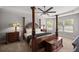Spacious main bedroom featuring a four-poster bed, bedside tables with lamps, and a ceiling fan at 5144 Ne 9Th St, Ocala, FL 34470