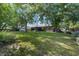 Expansive backyard with mature trees, green lawn, and the home's exterior in a serene setting at 5720 Se 22Nd Pl, Ocala, FL 34480