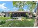 Lush backyard featuring green grass, mature trees, patio, and landscaping for outdoor enjoyment at 5720 Se 22Nd Pl, Ocala, FL 34480