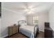 Cozy bedroom featuring a metal bed frame, wooden dresser, ceiling fan, and hardwood floors at 5720 Se 22Nd Pl, Ocala, FL 34480