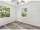 Bright bedroom with wood-look flooring and two windows looking out to the trees at 6840 Sw 198Th Ave, Dunnellon, FL 34431