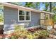 Exterior featuring gray wood siding, white trim, and a new wooden staircase with greenery in the foreground at 6840 Sw 198Th Ave, Dunnellon, FL 34431