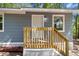 Close up of new wooden staircase leading to the front door of the home with gray wood siding at 6840 Sw 198Th Ave, Dunnellon, FL 34431