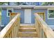 New wood staircase leading up to front door of home with gray wood siding and white trim at 6840 Sw 198Th Ave, Dunnellon, FL 34431