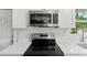Modern kitchen featuring stainless steel appliances, white cabinets, and a view to the outside at 6840 Sw 198Th Ave, Dunnellon, FL 34431