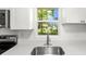 Bright kitchen features a stainless steel sink, modern faucet, and a view of the trees outside the window at 6840 Sw 198Th Ave, Dunnellon, FL 34431