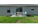 Back patio with table and chairs and manicured green lawn, perfect for relaxing at 7886 Sw 103Rd Loop, Ocala, FL 34476