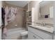 This bathroom features a shower with a shower curtain and a vanity with granite countertops at 7886 Sw 103Rd Loop, Ocala, FL 34476