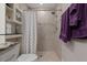 This bathroom features a tiled shower with a shower curtain and built in storage shelves at 7886 Sw 103Rd Loop, Ocala, FL 34476