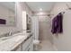 Bathroom featuring vanity with granite countertop, tiled shower and floors, and purple towels at 7886 Sw 103Rd Loop, Ocala, FL 34476