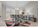 Bright dining area featuring modern chandelier, stylish table with seating and floor-to-ceiling windows at 7886 Sw 103Rd Loop, Ocala, FL 34476