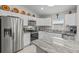 Bright kitchen featuring stainless steel appliances, white cabinets, and granite countertops at 7886 Sw 103Rd Loop, Ocala, FL 34476