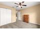 Bright bedroom boasts carpeting, closet with bi-fold doors, ceiling fan, and a standard door at 8 Hemlock Radl, Ocala, FL 34472