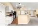 Modern kitchen with white cabinets, appliances, breakfast bar, and convenient access to the living area at 8 Hemlock Radl, Ocala, FL 34472