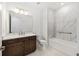 Bathroom featuring marble-tiled shower/tub, wood vanity, and bright lighting for a spa-like experience at 8497 Sw 99Th Cir, Ocala, FL 34481