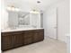 Bathroom has a double sink vanity with granite counters and dark cabinets at 8497 Sw 99Th Cir, Ocala, FL 34481