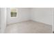 Bright, empty bedroom features neutral tile floors and a sunlit window at 8497 Sw 99Th Cir, Ocala, FL 34481