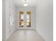 Bright entryway with double doors, neutral tile flooring, and a closet for added storage at 8497 Sw 99Th Cir, Ocala, FL 34481
