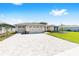 Attractive single-story home showcasing a paver driveway, three-car garage, and meticulously maintained lawn at 8497 Sw 99Th Cir, Ocala, FL 34481