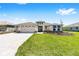 Inviting single-story home boasting a three-car garage, lush lawn, and beautifully landscaped front yard at 8497 Sw 99Th Cir, Ocala, FL 34481