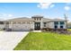Lovely single-story home featuring a three-car garage, vibrant lawn, and charming architectural details at 8497 Sw 99Th Cir, Ocala, FL 34481