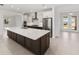 Modern kitchen with a large island, white cabinetry, stainless steel appliances, and granite countertops at 8497 Sw 99Th Cir, Ocala, FL 34481