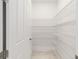 Spacious pantry featuring white wire shelving and a white door providing ample storage space at 8497 Sw 99Th Cir, Ocala, FL 34481
