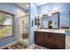 This bathroom has a glass shower, brown vanity, and natural light at 8630 Sw 20Th Ct, Ocala, FL 34476