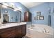 This bathroom features a soaking tub, marble countertops, and blue accent wall at 8630 Sw 20Th Ct, Ocala, FL 34476