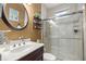 Bathroom featuring a glass shower, marble countertop, and round mirror at 8630 Sw 20Th Ct, Ocala, FL 34476