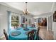 Dining room with natural light, elegant chandelier, and view to outdoor landscape at 8630 Sw 20Th Ct, Ocala, FL 34476