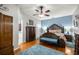 This primary bedroom features wood floors, ceiling fan, and blue accent wall at 8630 Sw 20Th Ct, Ocala, FL 34476