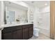 Bathroom featuring double sinks with dark wood cabinetry, large mirror, and a shower with tub at 8632 Sw 44Th Ter, Ocala, FL 34476