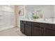 Bathroom featuring double sinks with dark wood cabinetry and a walk-in shower at 8632 Sw 44Th Ter, Ocala, FL 34476