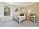 Bedroom with a large window, a bed with side tables and a white desk with woven stools at 8632 Sw 44Th Ter, Ocala, FL 34476