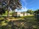 Large backyard with shed and plenty of space for outdoor activities with shade tree and partly cloudy sky at 910 Ne 11Th Ave, Ocala, FL 34470