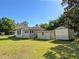 Expansive backyard featuring lush green grass, storage shed, and the house at 910 Ne 11Th Ave, Ocala, FL 34470