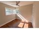 Cozy bedroom featuring hardwood floors, ceiling fan, and sunny bay windows at 910 Ne 11Th Ave, Ocala, FL 34470