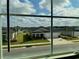 Neighborhood view showing well-maintained lawns and similar home styles, seen through a window at 9326 Sw 57Th Ter, Ocala, FL 34476
