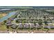Stunning aerial view of the community with a pond and meticulously landscaped homes and palm tree lined streets at 9443 Sw 71St Loop, Ocala, FL 34481