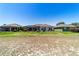The backyard view shows the lawn, landscaping, house and screened in lanai at 9443 Sw 71St Loop, Ocala, FL 34481