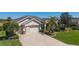 Home exterior featuring a brick paver driveway, well-maintained landscaping, and a two-car garage with plenty of parking at 9443 Sw 71St Loop, Ocala, FL 34481
