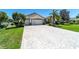 Home showcasing a brick paver driveway, lush landscaping, and a three-car garage, perfect for a growing Gathering at 9443 Sw 71St Loop, Ocala, FL 34481