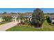An elevated view of a home featuring lush landscaping, mature trees, a well manicured lawn, and brick driveway at 9443 Sw 71St Loop, Ocala, FL 34481