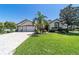 Spacious home exterior with a large, well-kept lawn, mature landscaping, and a three-car garage at 9443 Sw 71St Loop, Ocala, FL 34481