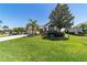 Green front lawn with tidy landscaping, and a beige two car garage home in a quiet suburban neighborhood at 9443 Sw 71St Loop, Ocala, FL 34481